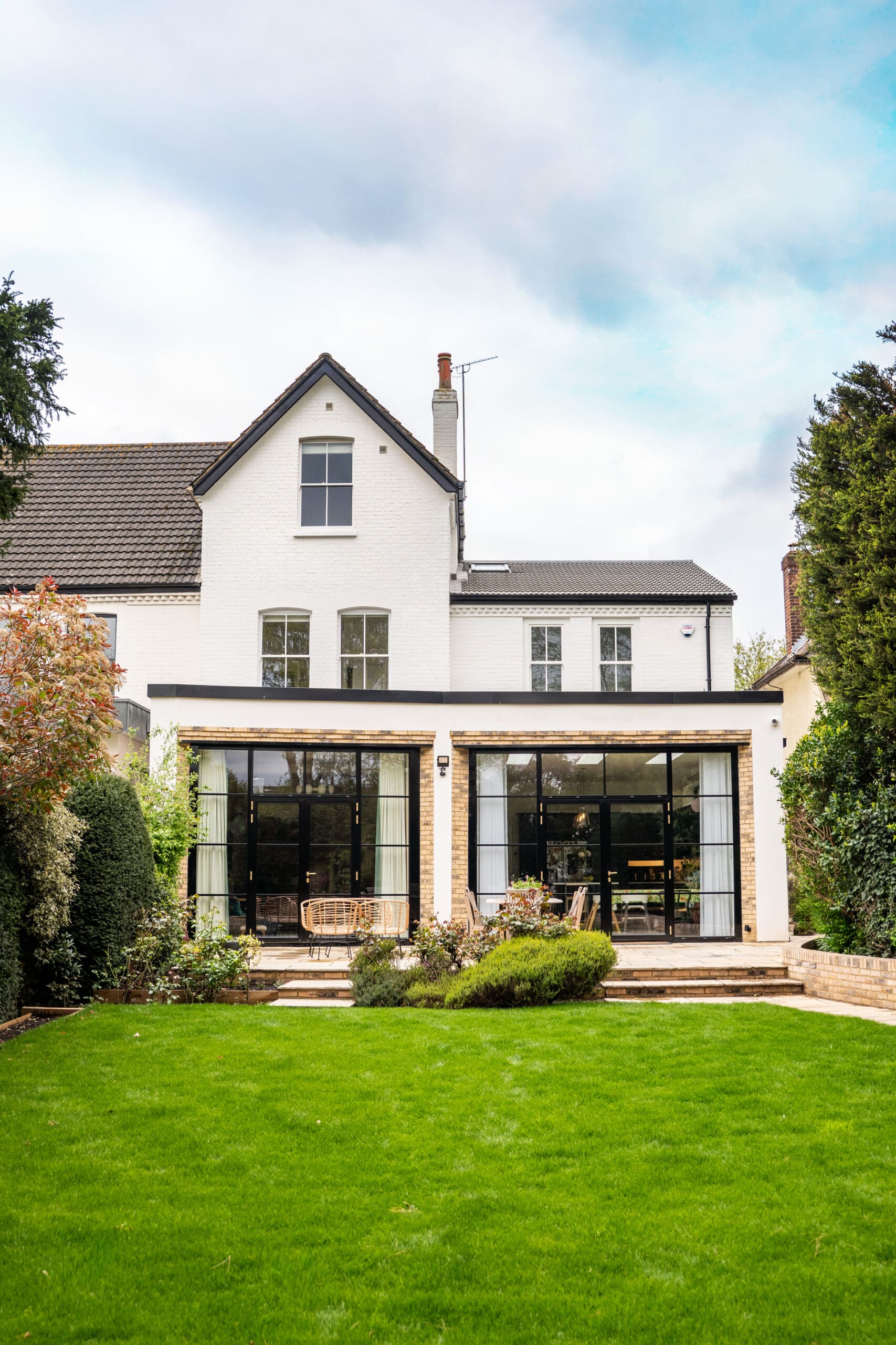 white house with rear extension with open windows / doors